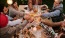 Friends at a table with their glasses touching in the center.