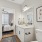 A bathroom with a white sink and a mirror.