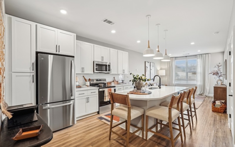  A modern kitchen with a large island and wooden floors.