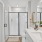 A white bathroom sink with a clear shower, a toilet, and a closet