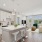 White kitchen with stainless steel appliances connected to a living room